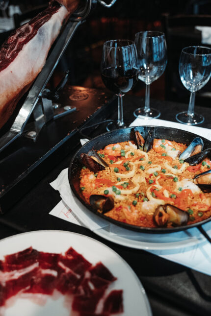 A serving of traditional paella alongside freshly carved Jamón Ibérico.