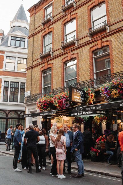 Group gathering outside tapas bar drinks party menus in Mayfair London