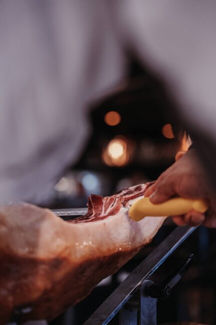 Chef thinly slicing fresh Jamón Ibérico from the leg